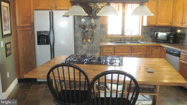 kitchen featuring dishwasher, white refrigerator with ice dispenser, sink, decorative backsplash, and gas cooktop