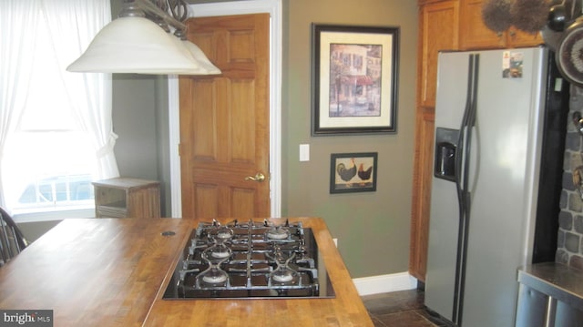 kitchen with wooden counters, stainless steel fridge with ice dispenser, and gas stovetop