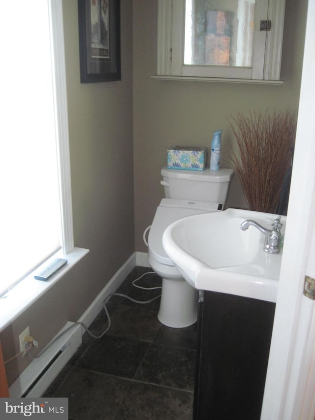 bathroom with toilet, vanity, and a baseboard heating unit