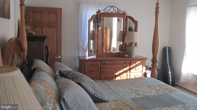 bedroom featuring baseboard heating and multiple windows