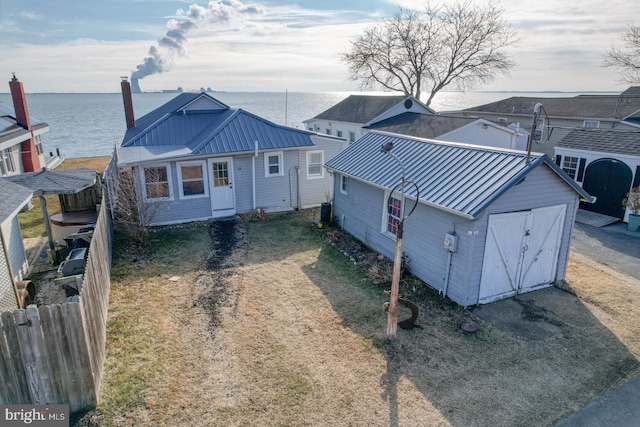 view of front of house featuring a water view and a storage shed