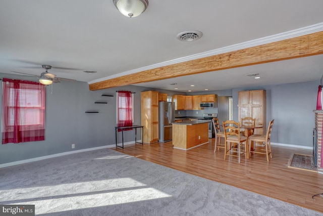 kitchen featuring appliances with stainless steel finishes, a breakfast bar, a center island, light hardwood / wood-style floors, and crown molding