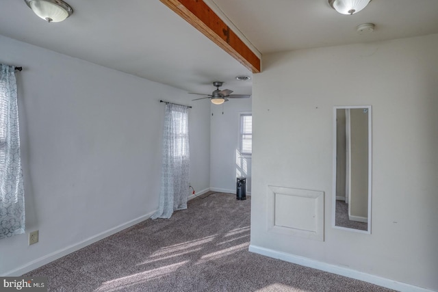 carpeted spare room featuring ceiling fan and beam ceiling