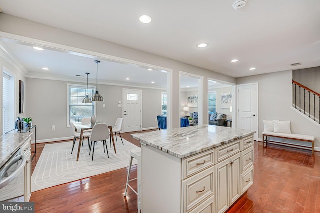 kitchen featuring light stone countertops, pendant lighting, dishwasher, hardwood / wood-style floors, and a center island