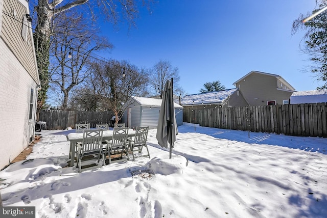 yard layered in snow with a shed