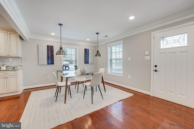 dining area with light hardwood / wood-style floors and ornamental molding