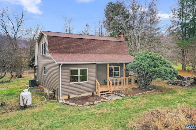 view of front facade with a deck, a front lawn, and cooling unit