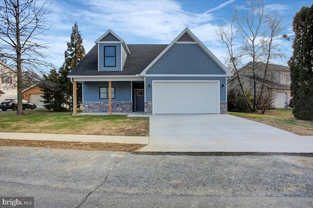 view of front of property with covered porch, a garage, and a front yard