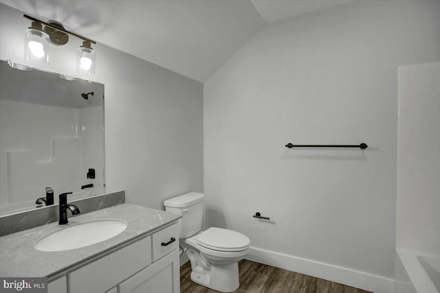 bathroom featuring vanity, vaulted ceiling, toilet, walk in shower, and wood-type flooring