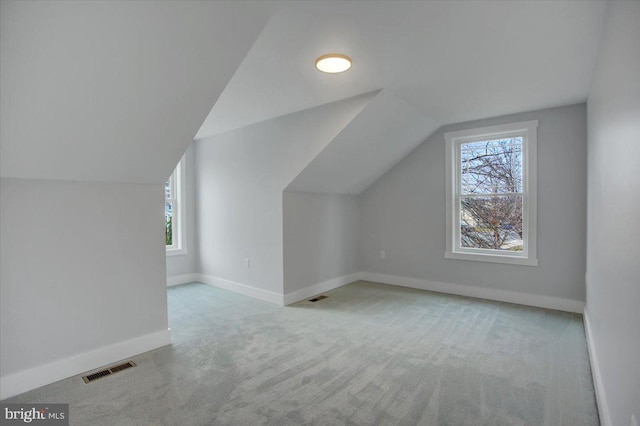 bonus room featuring light colored carpet and lofted ceiling