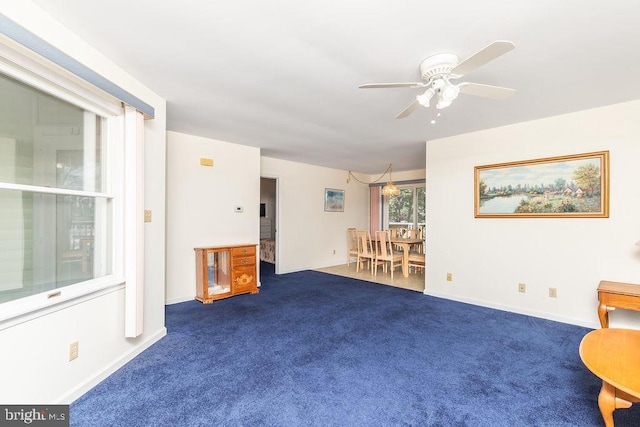 sitting room with dark colored carpet and ceiling fan