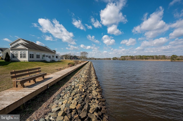 view of dock featuring a water view and a yard