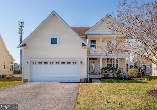 view of front of house with cooling unit, covered porch, a front yard, and a garage