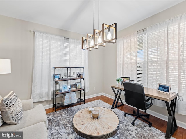 office area with hardwood / wood-style floors and an inviting chandelier