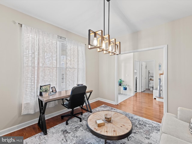 office area featuring wood-type flooring and an inviting chandelier