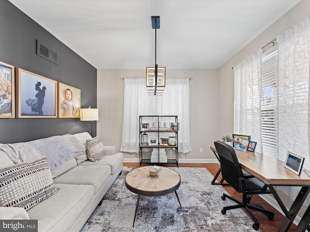 office with hardwood / wood-style floors and a chandelier