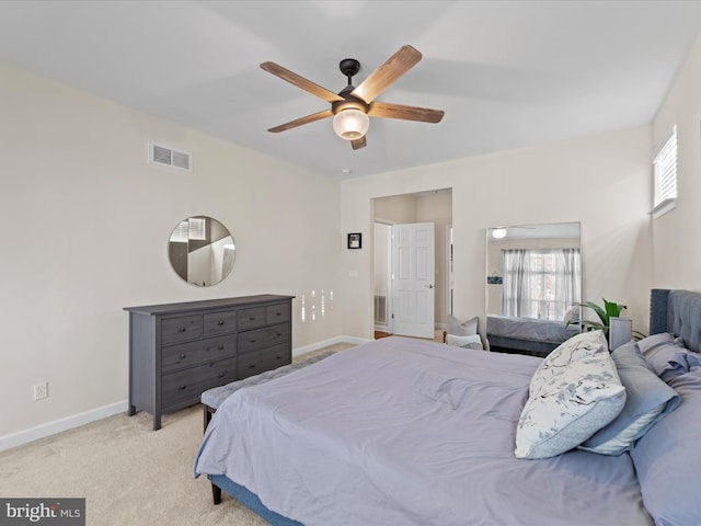 bedroom featuring ceiling fan, light colored carpet, and multiple windows