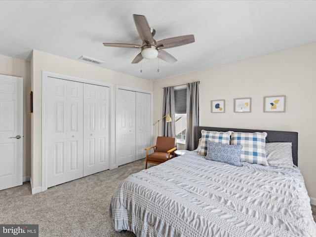 carpeted bedroom featuring ceiling fan and two closets