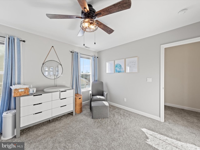 sitting room with ceiling fan and light colored carpet