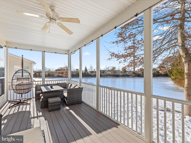 sunroom / solarium featuring ceiling fan and a water view