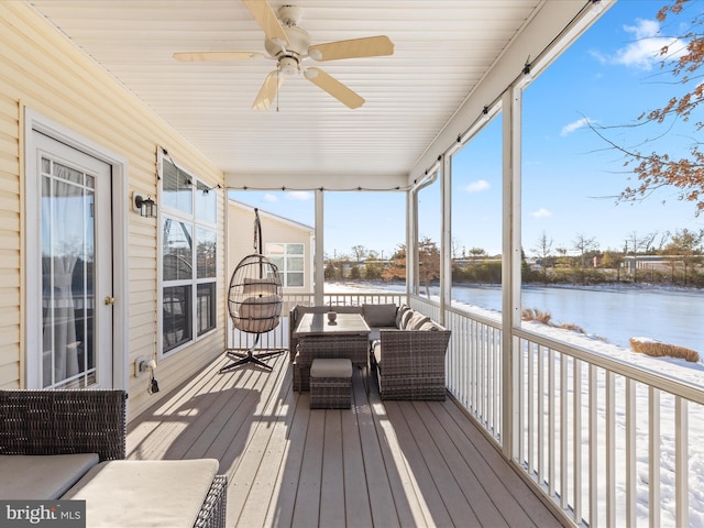 sunroom featuring a water view, ceiling fan, and a healthy amount of sunlight