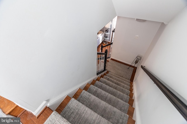 stairs with lofted ceiling and hardwood / wood-style flooring