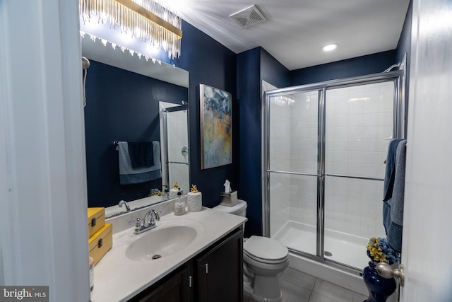 bathroom featuring toilet, vanity, tile patterned floors, and walk in shower