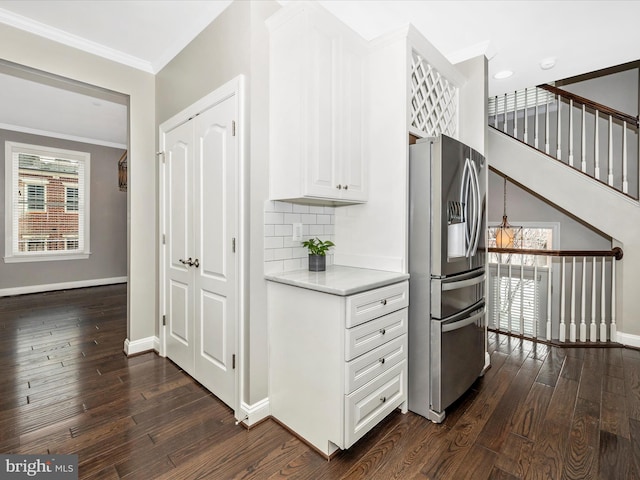 kitchen with dark hardwood / wood-style flooring, white cabinets, stainless steel fridge with ice dispenser, and ornamental molding