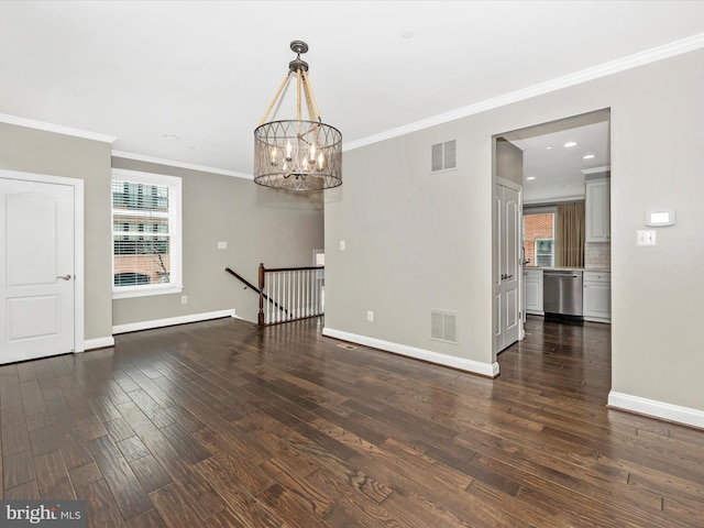 empty room with a chandelier, crown molding, and dark hardwood / wood-style floors