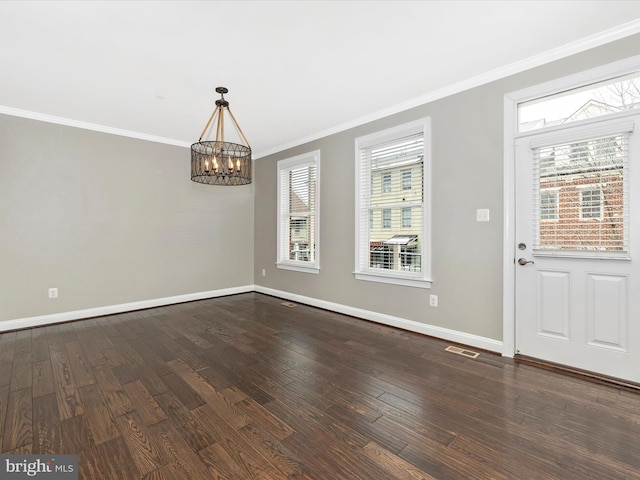 unfurnished dining area with dark hardwood / wood-style flooring, ornamental molding, and an inviting chandelier