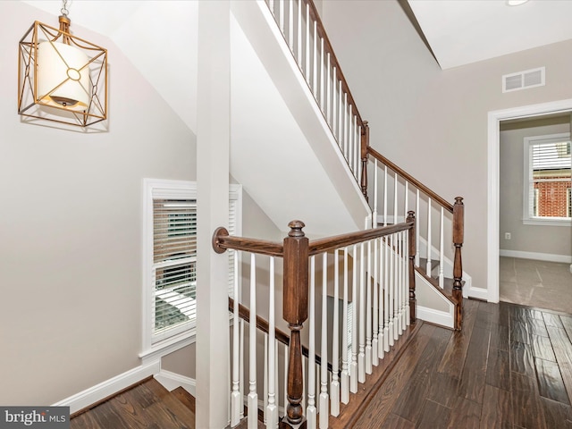 stairway with vaulted ceiling and wood-type flooring