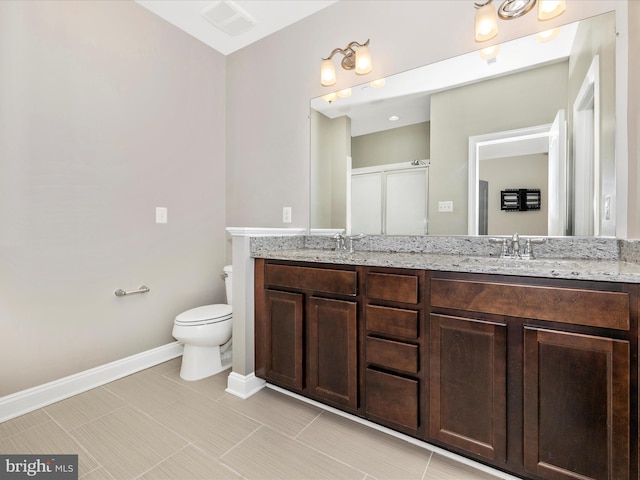 bathroom featuring a shower with door, toilet, and vanity