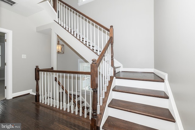 staircase with hardwood / wood-style flooring, a wealth of natural light, and vaulted ceiling