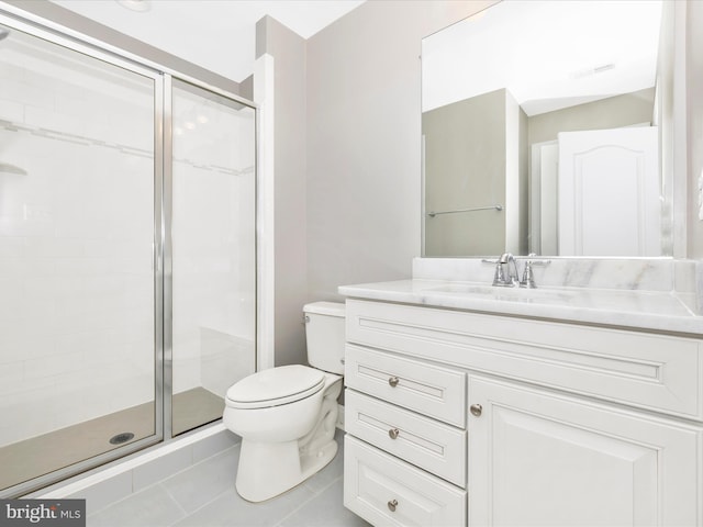 bathroom featuring a shower with shower door, toilet, vanity, and tile patterned flooring