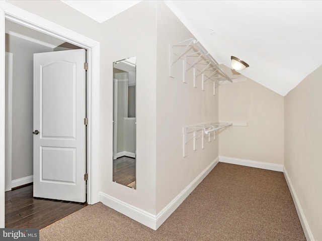 walk in closet featuring dark carpet