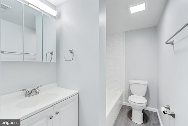 full bathroom with hardwood / wood-style flooring, shower / washtub combination, vanity, and toilet