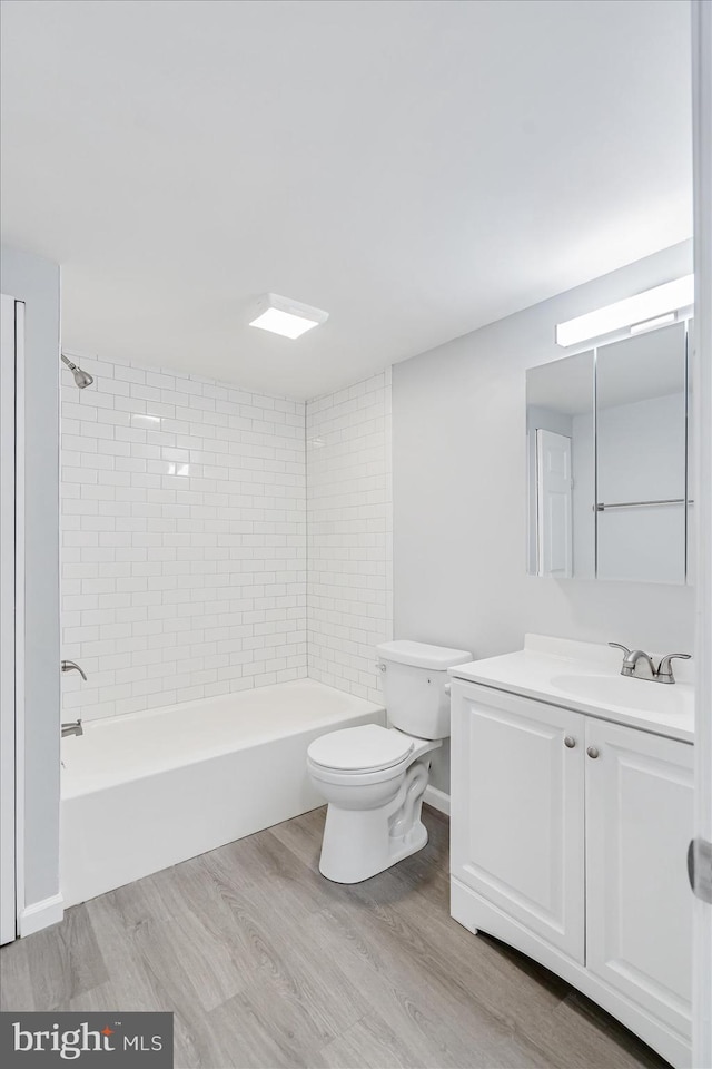 full bathroom with wood-type flooring, vanity, toilet, and tiled shower / bath combo