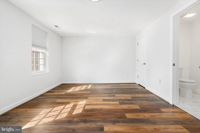 spare room with dark hardwood / wood-style floors