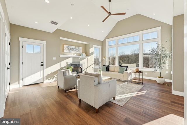 living room featuring dark hardwood / wood-style flooring, high vaulted ceiling, and ceiling fan