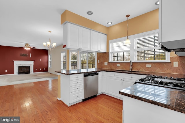 kitchen with white cabinets, stainless steel dishwasher, hanging light fixtures, and sink