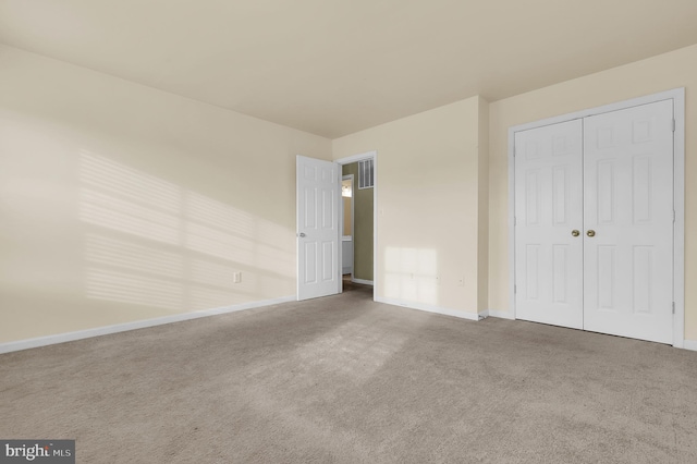 unfurnished bedroom with a closet and carpet floors