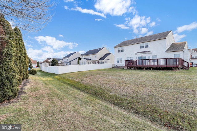 back of property with a lawn and a wooden deck