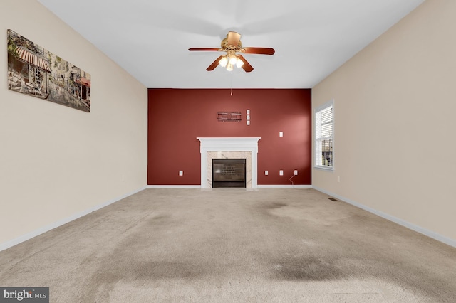 unfurnished living room featuring ceiling fan, a fireplace, and carpet