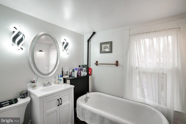 bathroom with vanity, toilet, and a tub