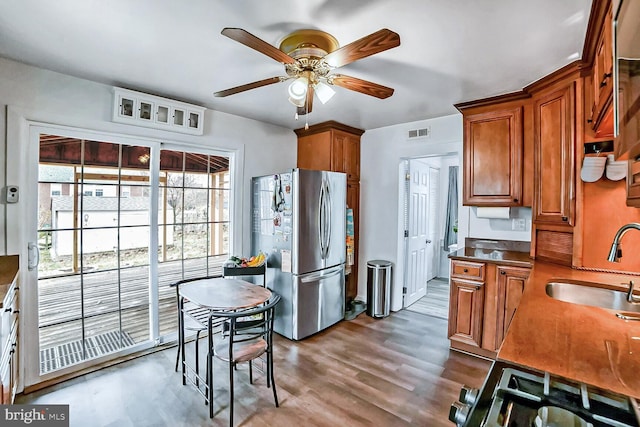 kitchen featuring ceiling fan, wood-type flooring, sink, and stainless steel refrigerator