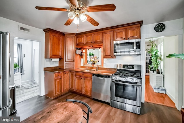 kitchen with ceiling fan, sink, dark wood-type flooring, and appliances with stainless steel finishes