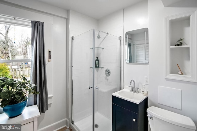 bathroom with vanity, a shower with shower door, and toilet