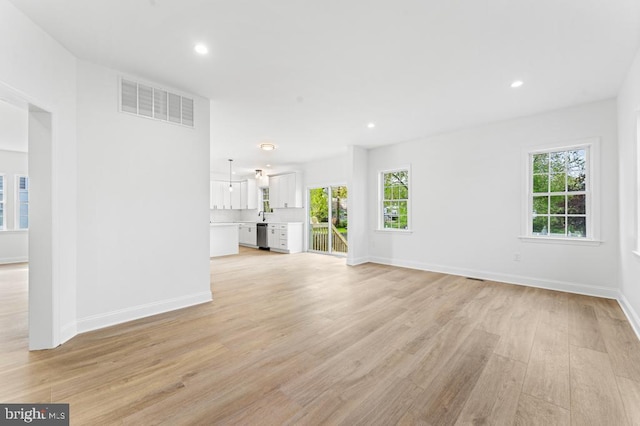 unfurnished living room with plenty of natural light and light hardwood / wood-style floors