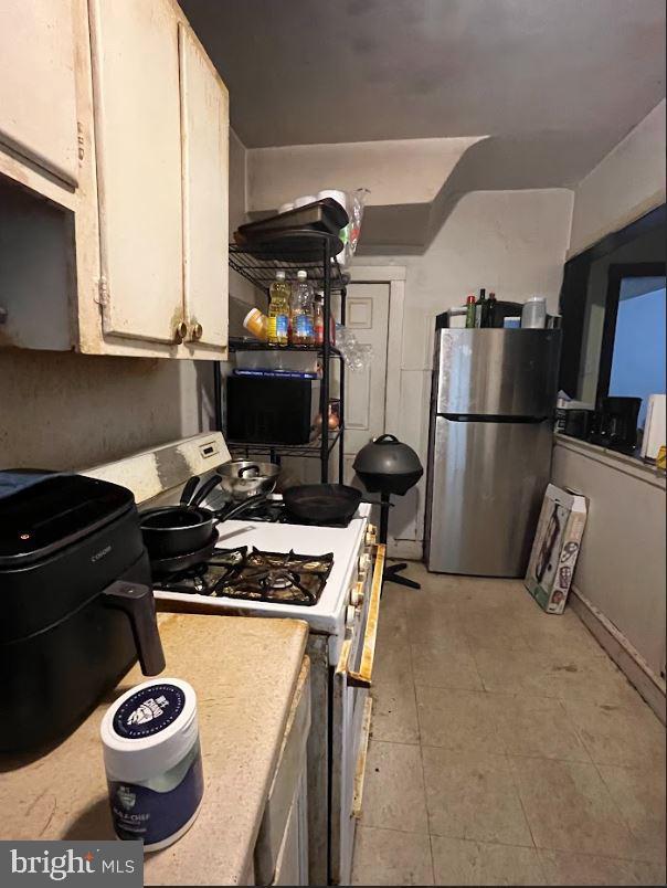 kitchen featuring stainless steel fridge and white gas range oven