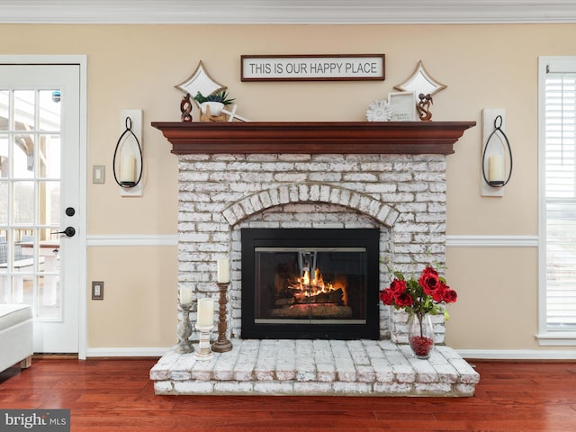 interior details featuring hardwood / wood-style floors, crown molding, and a brick fireplace